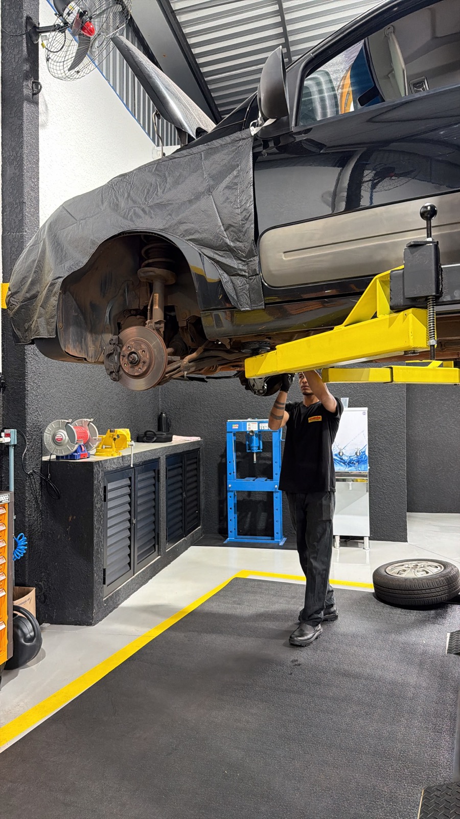 Mecânico trabalhando em veículo elevado